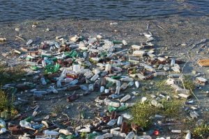 Image shows the tide of waste on a beach to illustrate the floating rubbish dump, marine pollution problem.