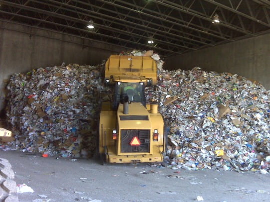 Image shows a front loader vehicle in a waste transfer station.