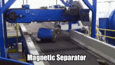 A magnetic separator in action, detects a drum and removes it from a conveyor belt.