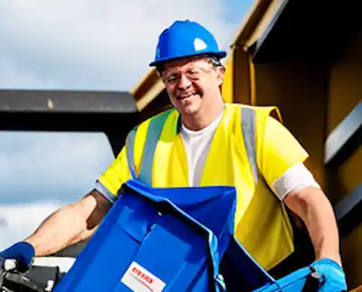 A landfill site worker moving trash.